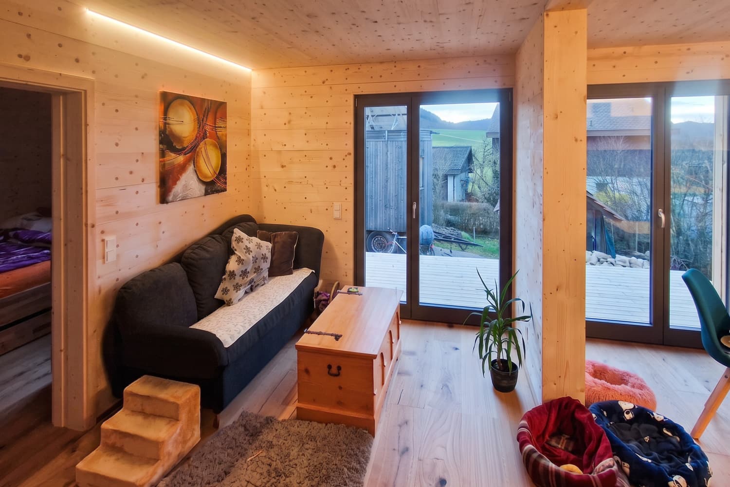 ZINIPI 3-ModulHaus in Gallenkirch AG: Wohnzimmer mit Fenstertür zur Terrasse