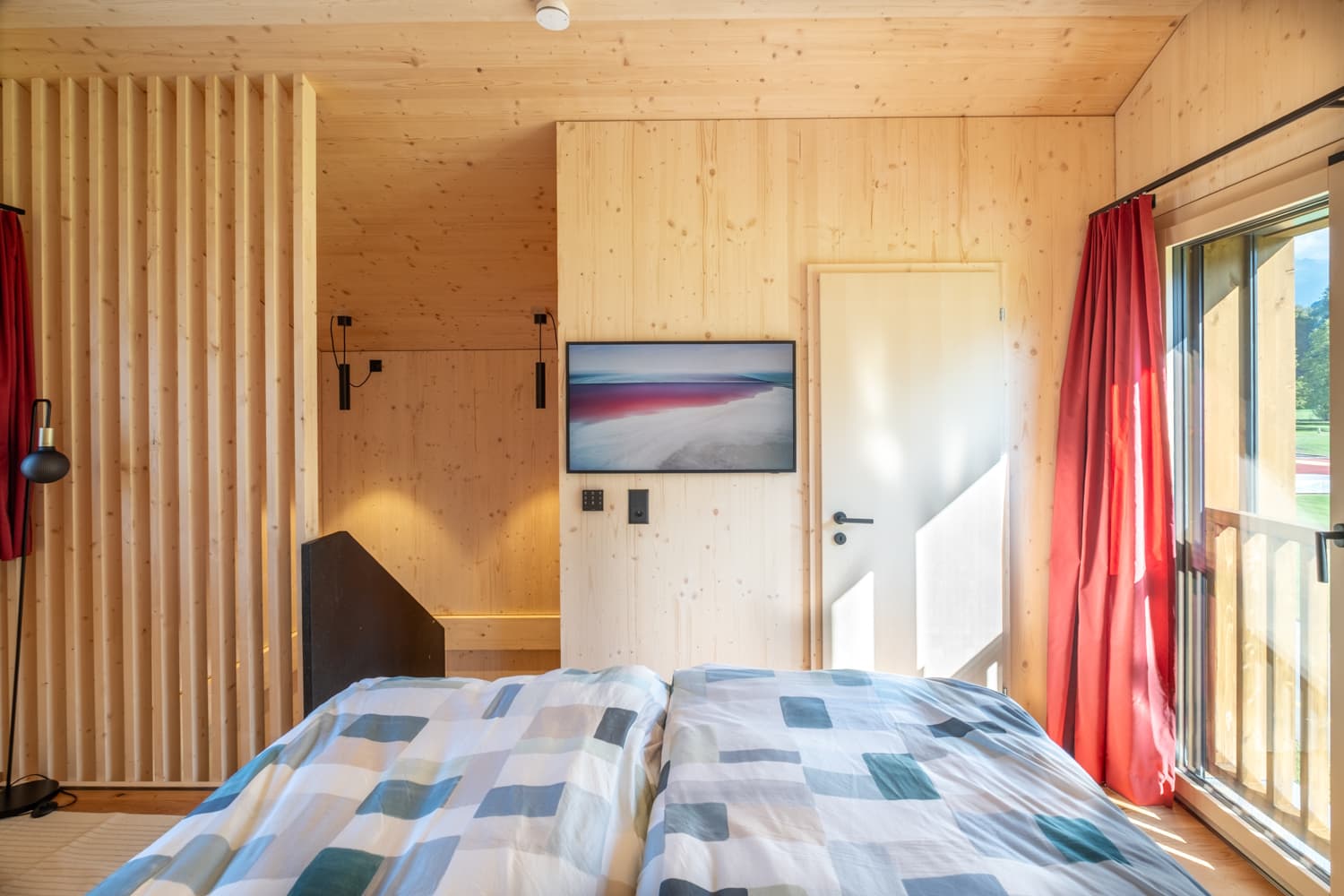 VIVĀN ELEMENT SwissBijou in Stans: Schlafbereich mit Holzlamellenwand