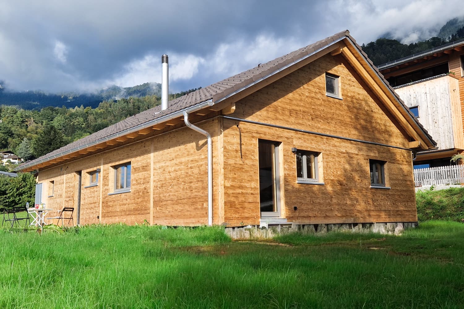 ZINIPI 4-ModulHaus in Triesen FL: Längsseite mit Wiese und Bergkulisse